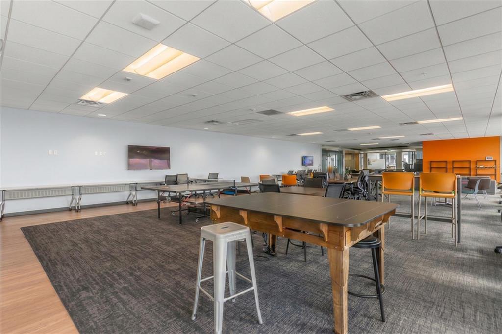A modern office break room features a ping pong table, high-top tables, and carpeted flooring — 189 S ORANGE AVENUE UNIT 1930S, ORLANDO, FL
