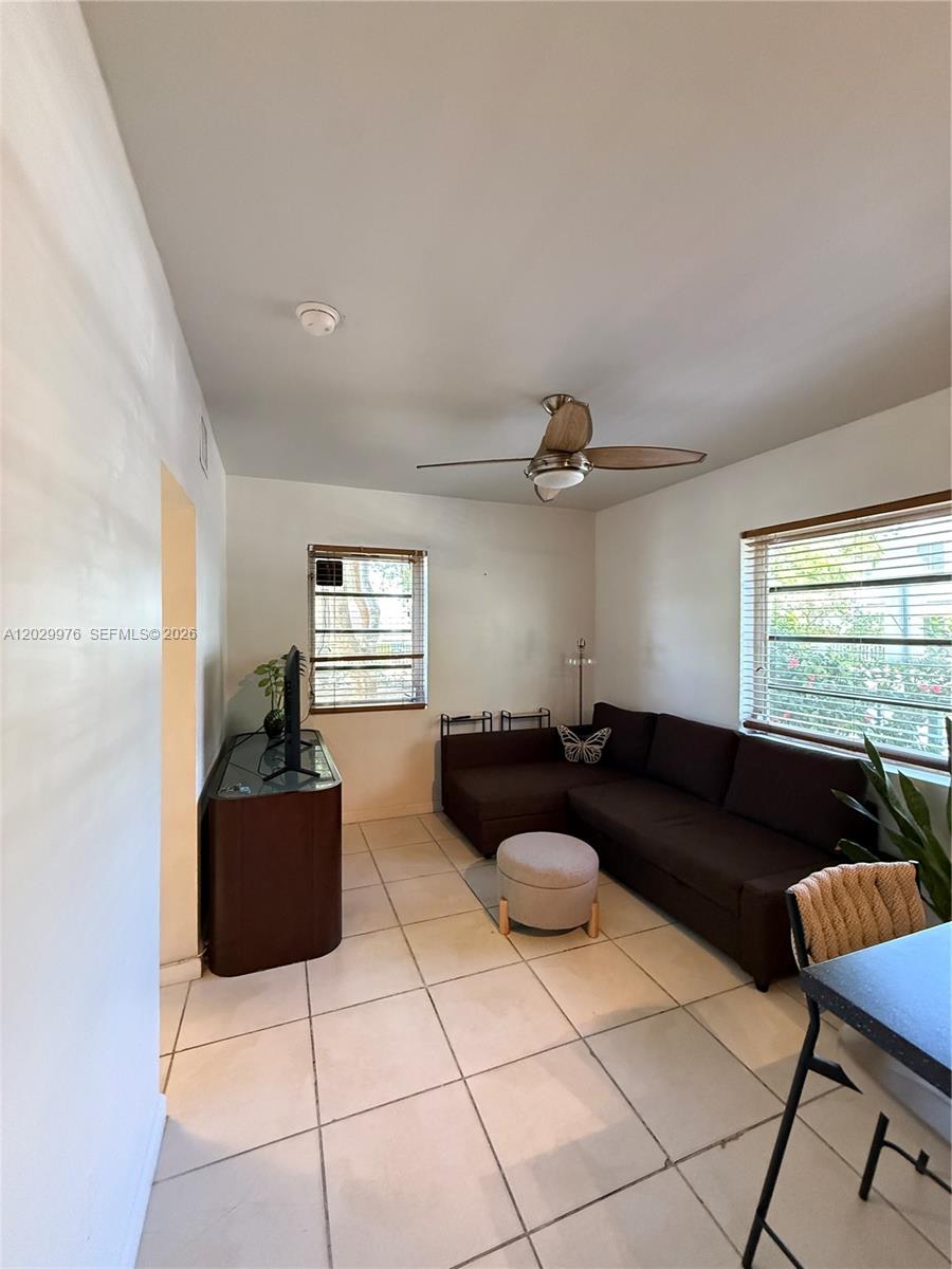 A living room features white walls, tile flooring, a brown sectional sofa, and a ceiling fan — 601 Michigan Ave # 3, Miami Beach FL 33139, MIAMI BEACH, FL