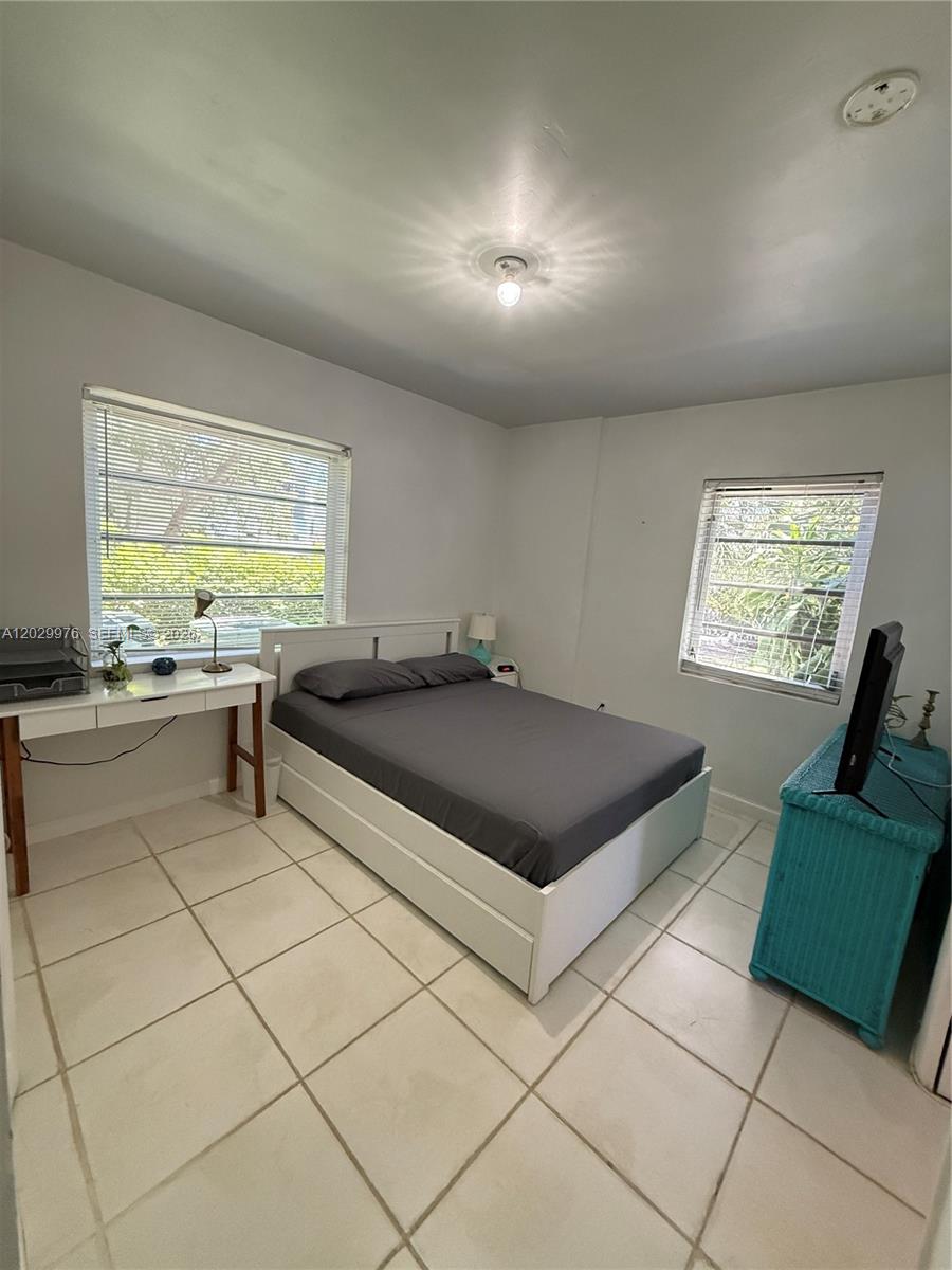 A bedroom features a bed, a desk, a teal dresser, and tiled flooring — 601 Michigan Ave # 3, Miami Beach FL 33139, MIAMI BEACH, FL