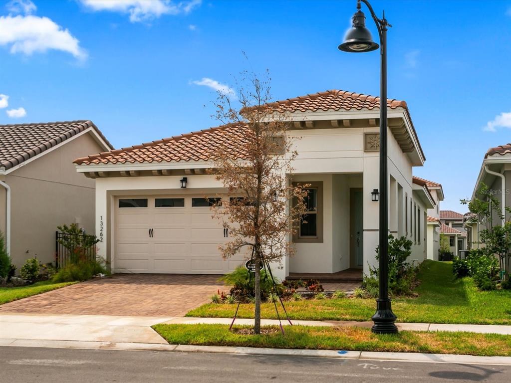 A single-story house with a tiled roof, a two-car garage, and a front yard — 13262 WINTERTON LANE, ORLANDO, FL