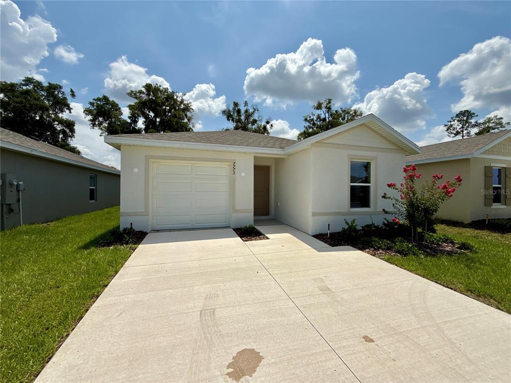 A single-story house with a white stucco exterior, a one-car garage, and a concrete driveway — 7773 SW 46TH COURT, OCALA, FL