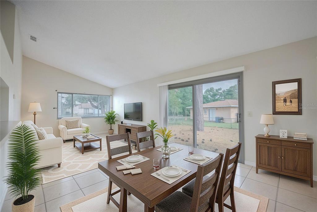 A living and dining room with tile floors, vaulted ceilings, and a sliding glass door — 21 SPRING LOOP CIRCLE, OCALA, FL