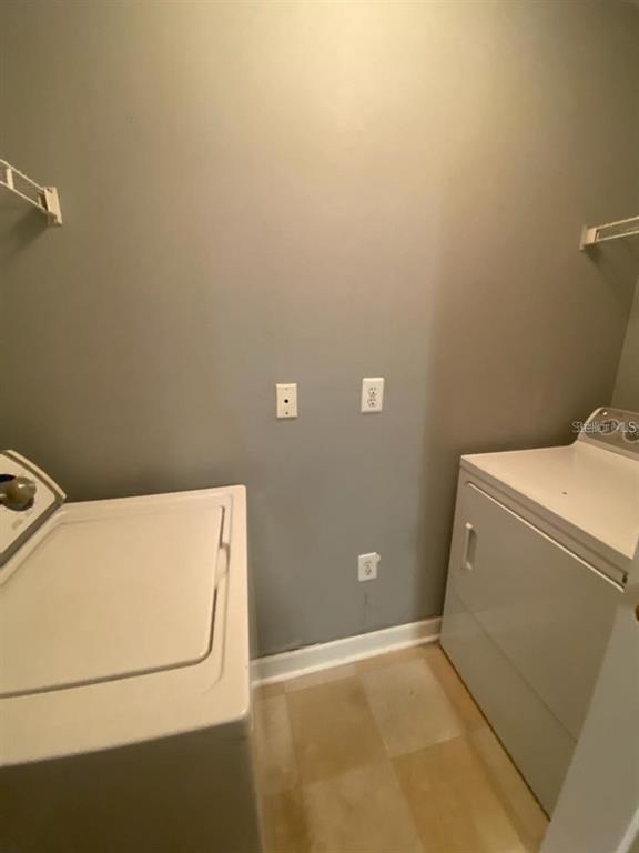 A laundry room with a washer, a dryer, and light-colored vinyl flooring — 18489 BRIDLE CLUB DRIVE UNIT 184k, TAMPA, FL