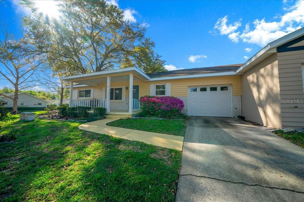 A single-story house with yellow siding, a front porch, and an attached one-car garage — 8702 SW 94TH STREET UNIT A, OCALA, FL