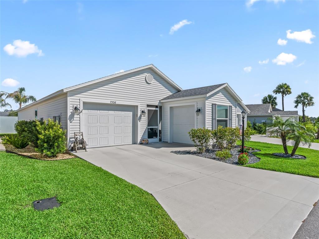 A light-colored, single-story suburban house features a two-car garage and a concrete driveway — 7536 KUENHER COURT, THE VILLAGES, FL