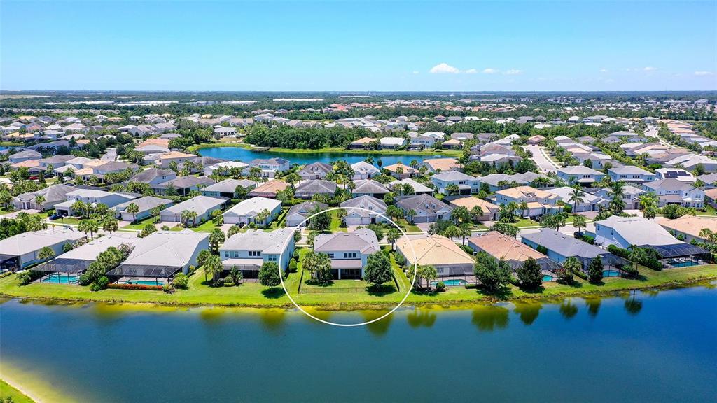 An aerial view of a suburban house with a pool, situated along a lake — 12318 BLUE HILL TRAIL, BRADENTON, FL