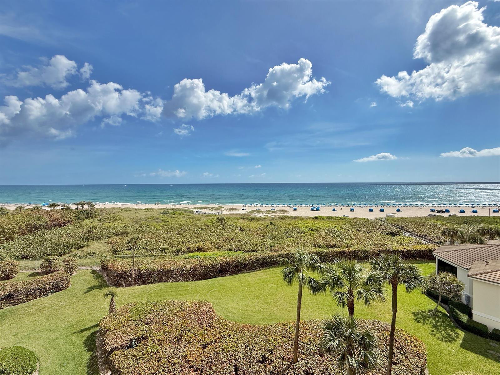 An elevated view of a grassy lawn, palm trees, and sand dunes overlooking the ocean — 3000 N Ocean Drive, Singer Island FL 33404, SINGER ISLAND, FL