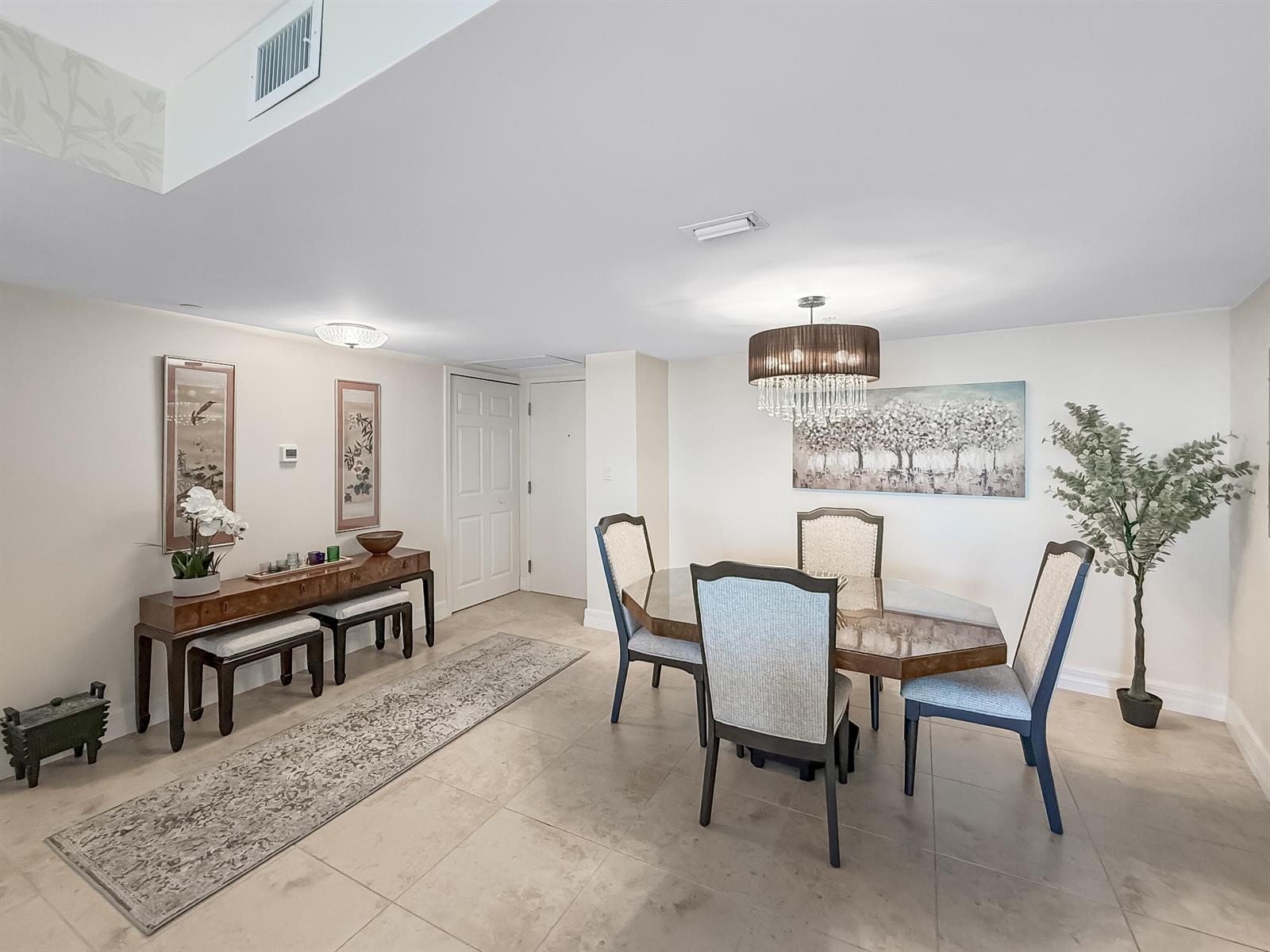 A dining area features a glass-topped table, upholstered chairs, a console table, and tile flooring — 3000 N Ocean Drive, Singer Island FL 33404, SINGER ISLAND, FL