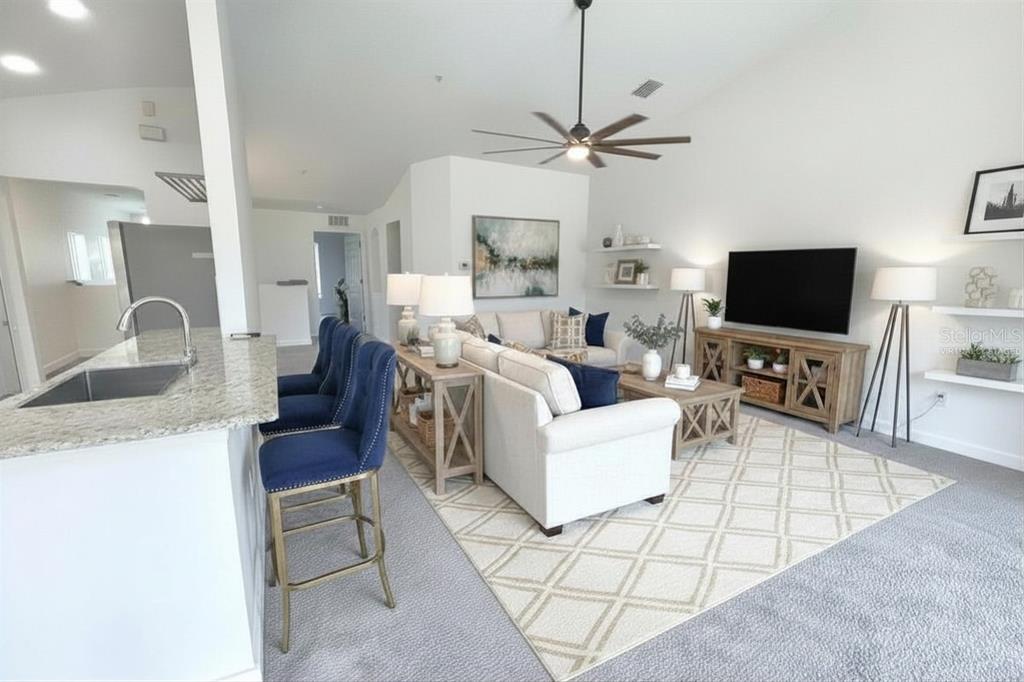 A living room with a white sofa, blue bar stools, and a television on a console — 2096 KINGS PALACE DRIVE, RIVERVIEW, FL