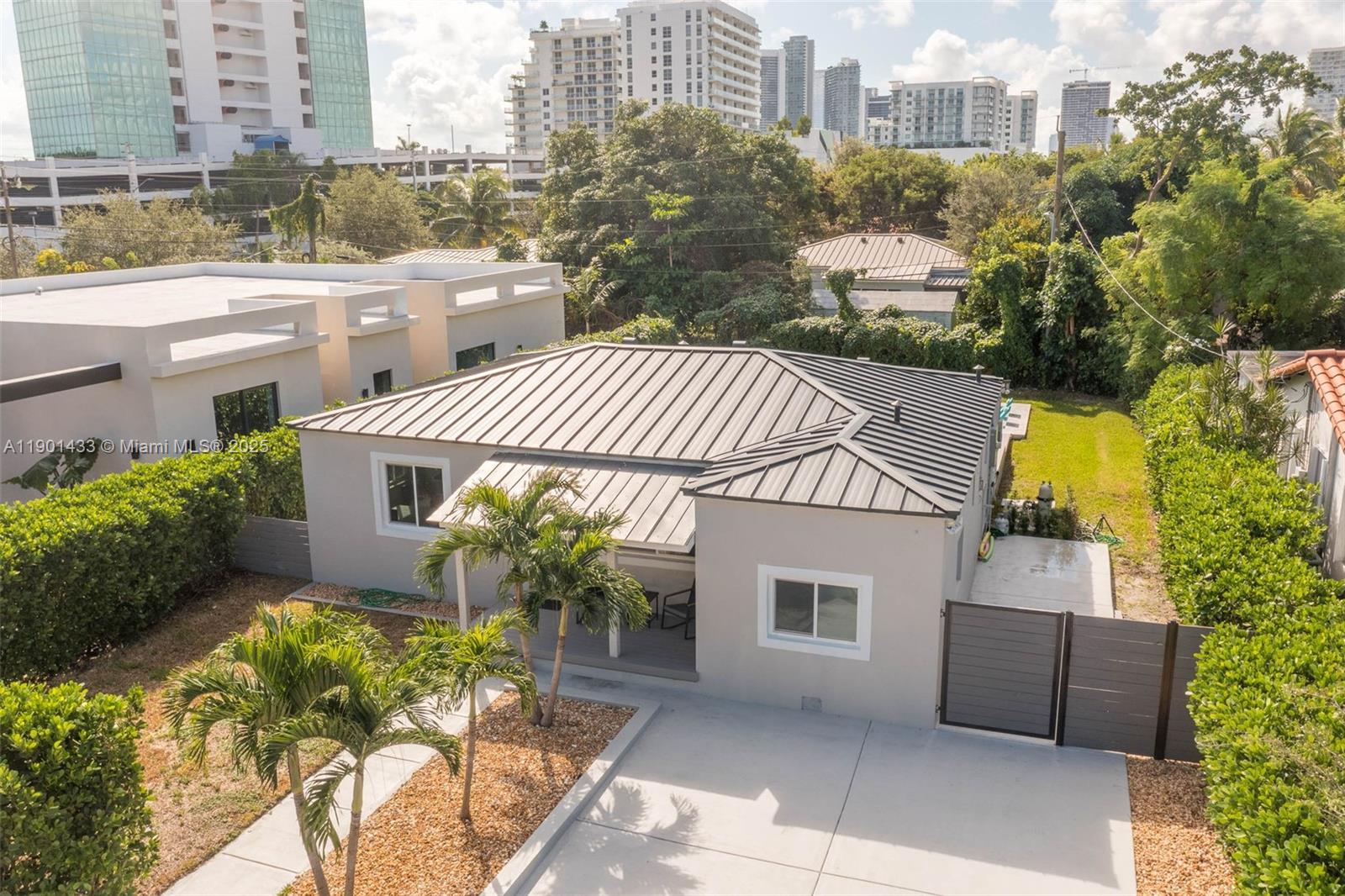 An aerial view shows a single-story house with a metal roof and a concrete driveway — 260 NE 46th St, Miami FL 33137, MIAMI, FL