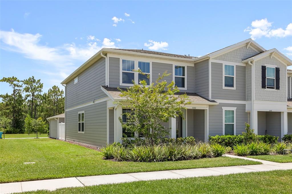 A two-story gray house with white trim and a small front yard — 5592 PINELAND RUN, ORLANDO, FL