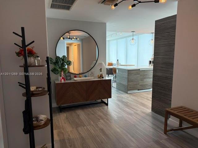 A modern entryway features a circular mirror, a wooden console table, and a coat rack — 460 NE 28th St # 3408, Miami FL 33137, MIAMI, FL