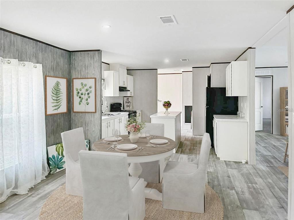 A dining area with a round table and four chairs sits before an open kitchen — 1259 ROSEWOOD STREET, BUNNELL, FL