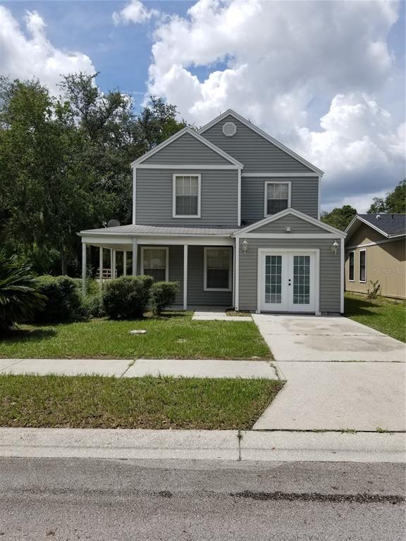 A two-story gray house with a front porch and double glass doors — 8202 BROWARD PLACE, TEMPLE TERRACE, FL