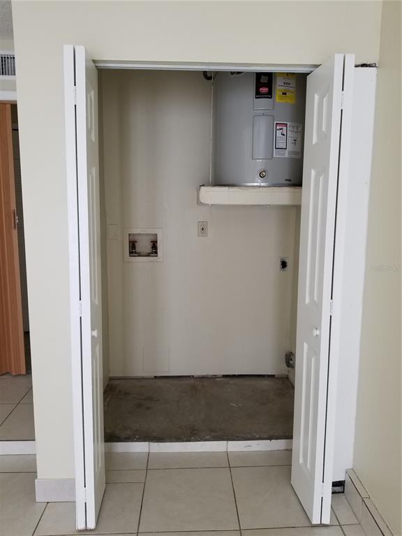 A closet contains a water heater and laundry hookups with tile flooring — 8202 BROWARD PLACE, TEMPLE TERRACE, FL