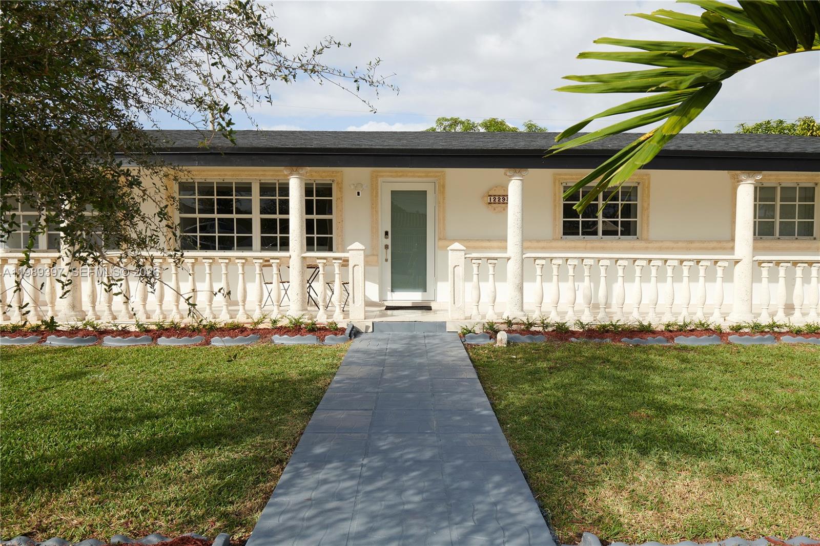A single-story house features a white facade, a balustrade porch, and a central front door — 12293 SW 28th Ter, Miami FL 33175, MIAMI, FL