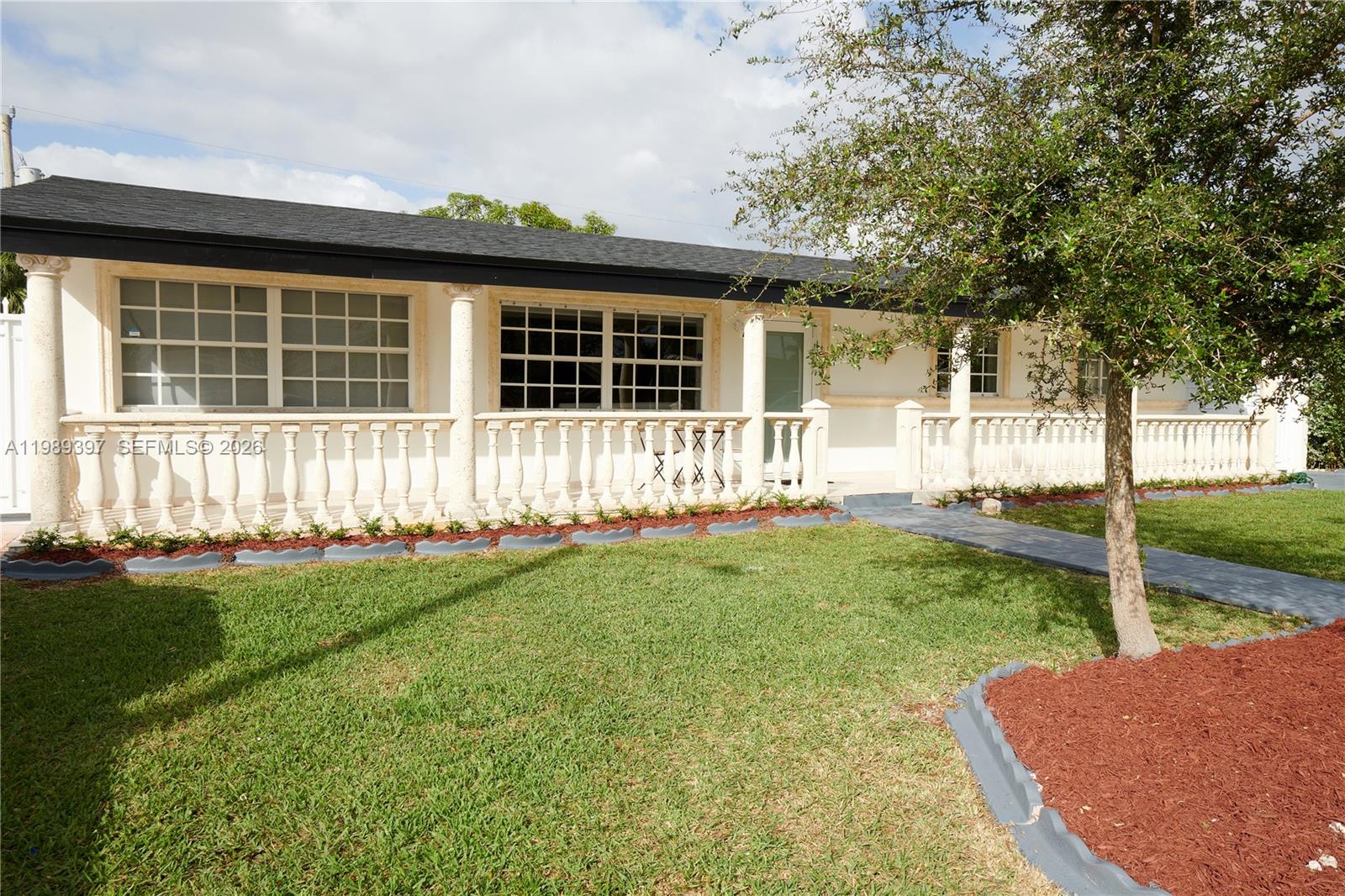 A single-story house features a white facade, a balustrade porch, and a dark shingled roof — 12293 SW 28th Ter, Miami FL 33175, MIAMI, FL