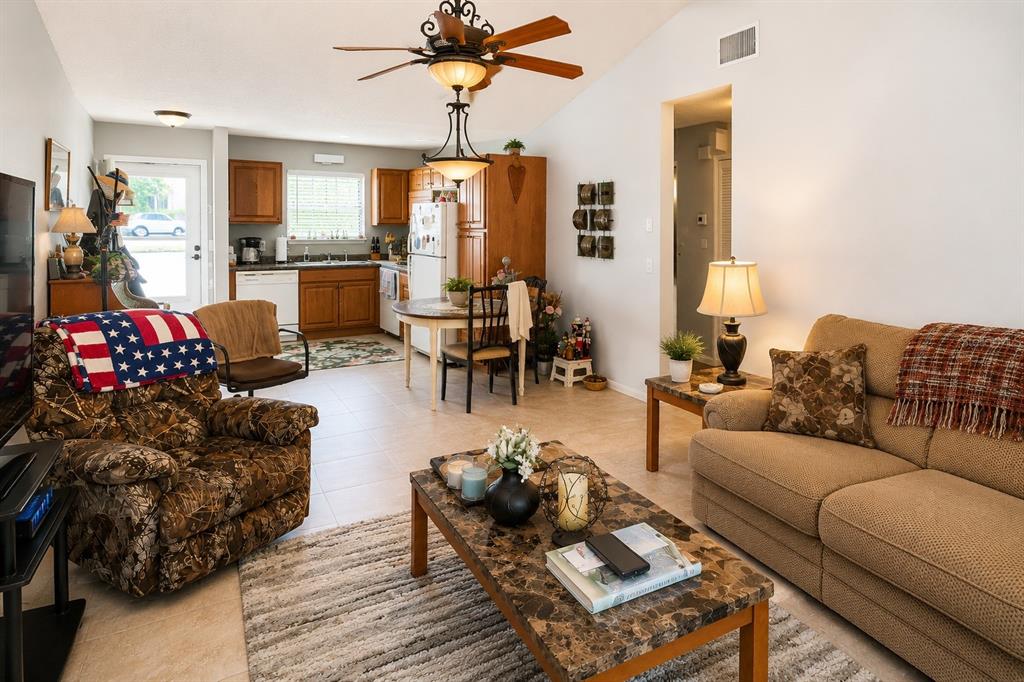A living room and kitchen area with tile flooring, a ceiling fan, and neutral walls — 1126 FAIRVILLA DRIVE UNIT 1126, NEW SMYRNA BEACH, FL