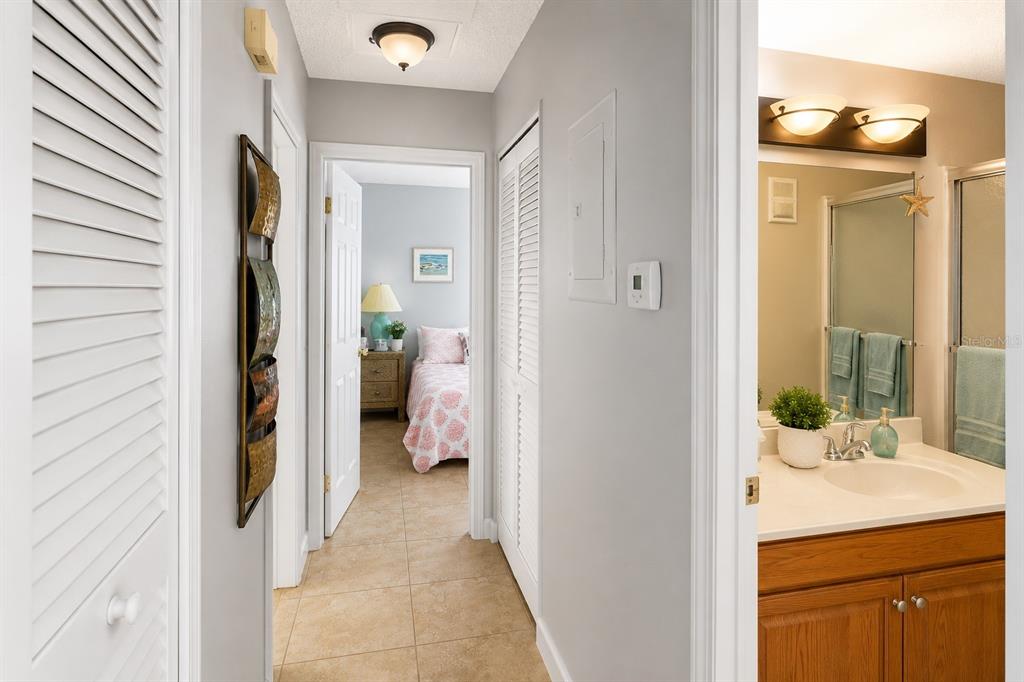 A hallway with tile flooring leads to a bedroom, with a bathroom visible on the right — 1126 FAIRVILLA DRIVE UNIT 1126, NEW SMYRNA BEACH, FL