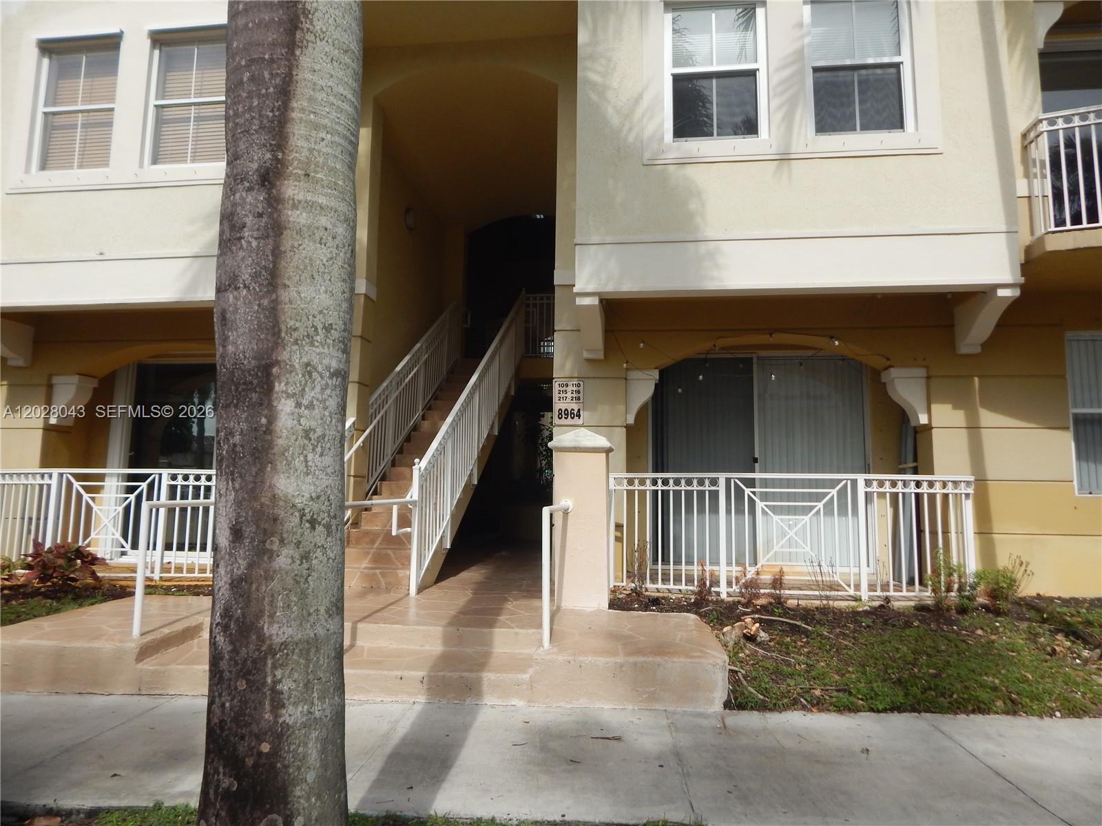 An exterior view of a multi-story apartment building with a central staircase and balconies — 8964 W Flagler St # 109, Miami FL 33174, MIAMI, FL