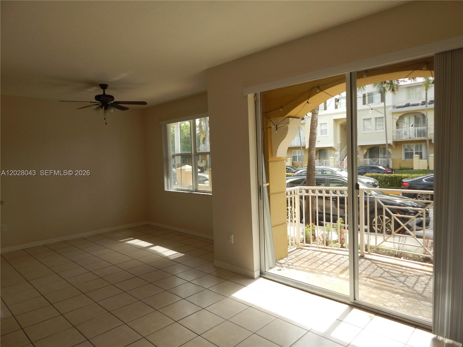An empty room features light-colored tile flooring, a ceiling fan, and a sliding glass door — 8964 W Flagler St # 109, Miami FL 33174, MIAMI, FL