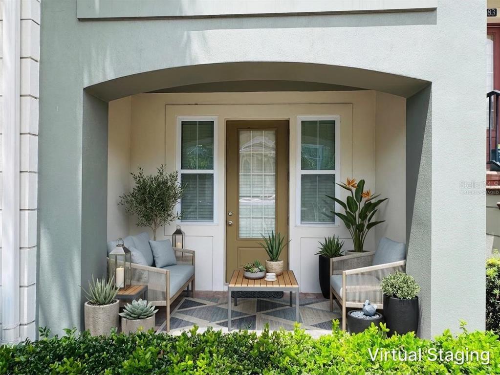 A covered patio features a small seating area with two chairs, a table, and plants — 2583 JOSLIN PLACE, ORLANDO, FL