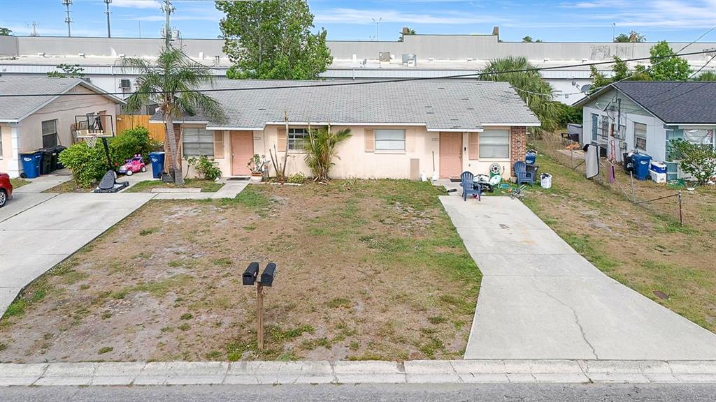 An exterior view of a single-story duplex with two concrete driveways and a front lawn — 6520/6522 12TH STREET W, BRADENTON, FL