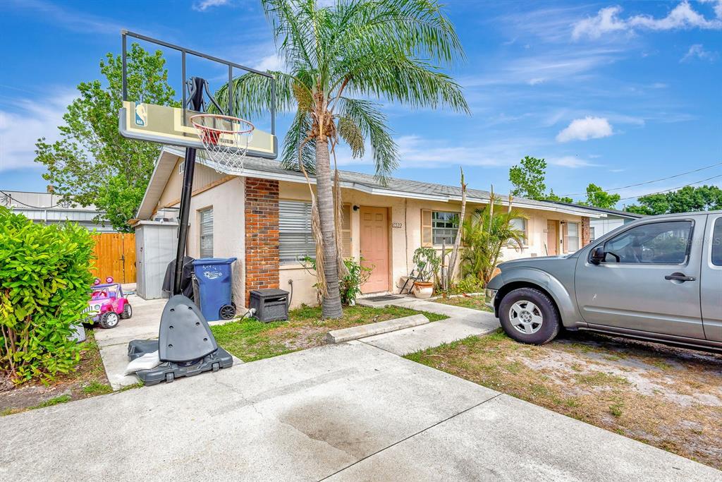 A single-story house exterior features a concrete driveway, a basketball hoop, and a palm tree — 6520/6522 12TH STREET W, BRADENTON, FL