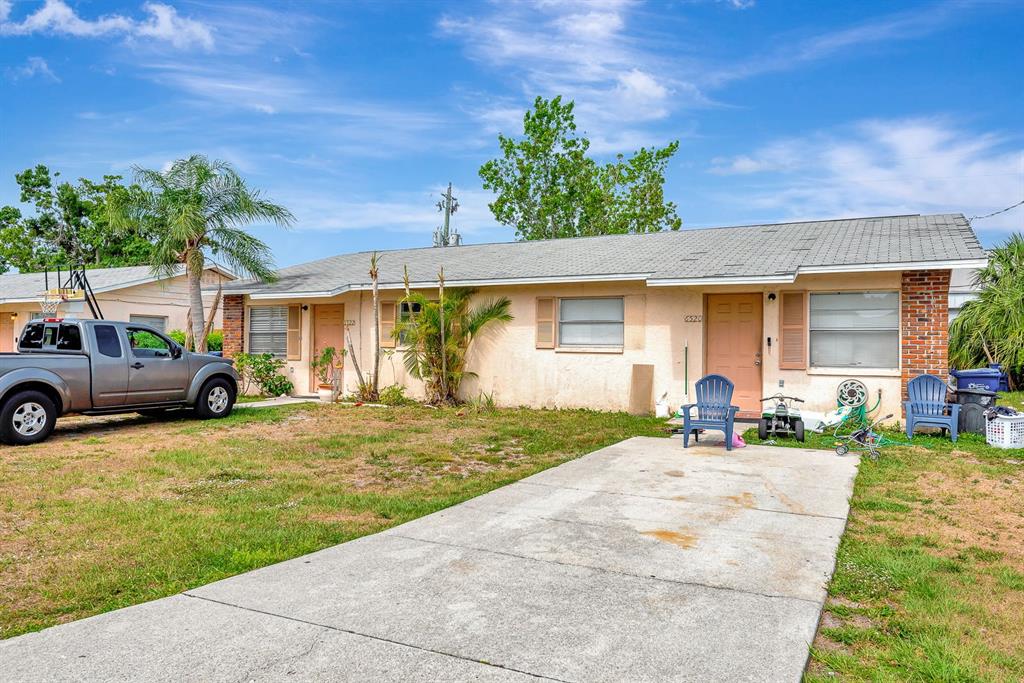 A single-story duplex with a concrete driveway, two front doors, and a parked pickup truck — 6520/6522 12TH STREET W, BRADENTON, FL