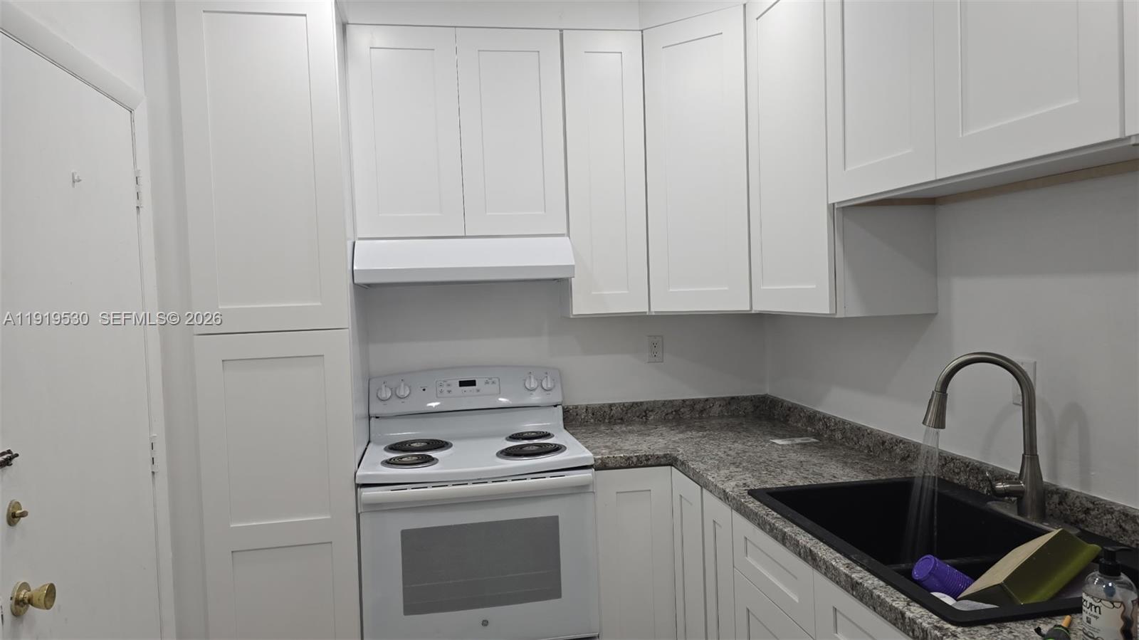 A kitchen features white shaker cabinets, a white electric stove, and a dark sink — 9159 SW 77th Ave # 211, Miami FL 33156, MIAMI, FL