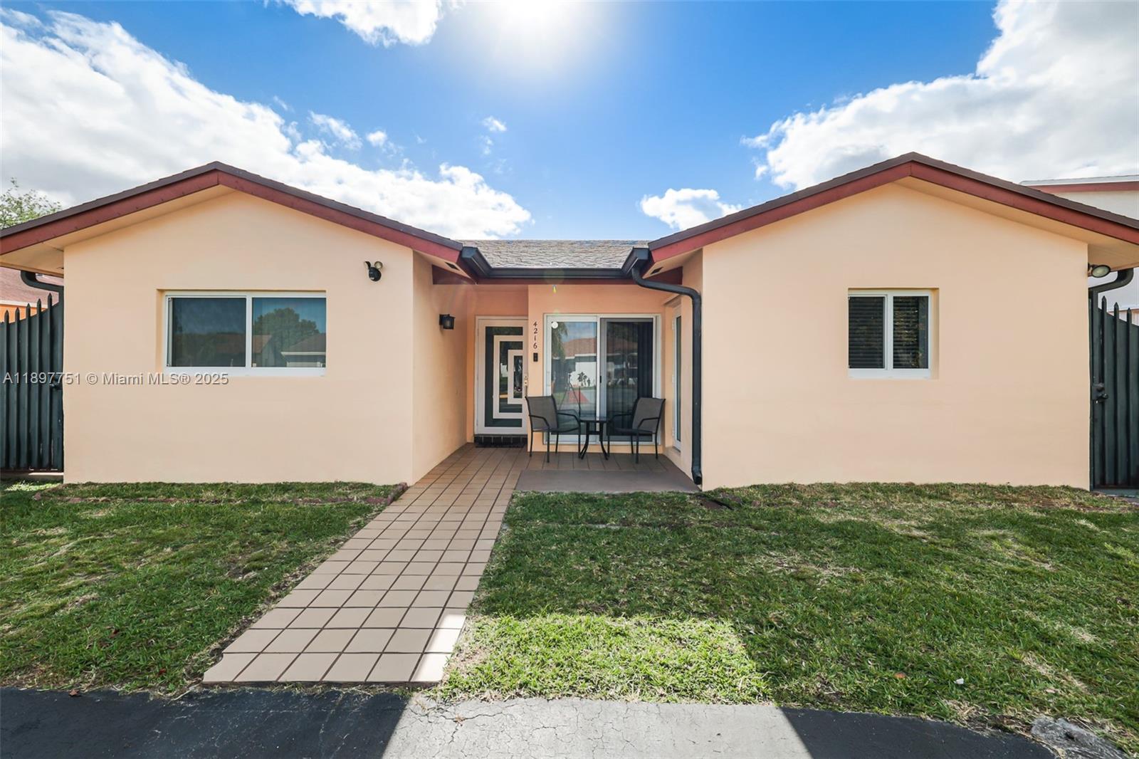 A single-story peach-colored house features a tiled walkway leading to a recessed front entrance — 4216 SW 138th Ct, Miami FL 33175, MIAMI, FL