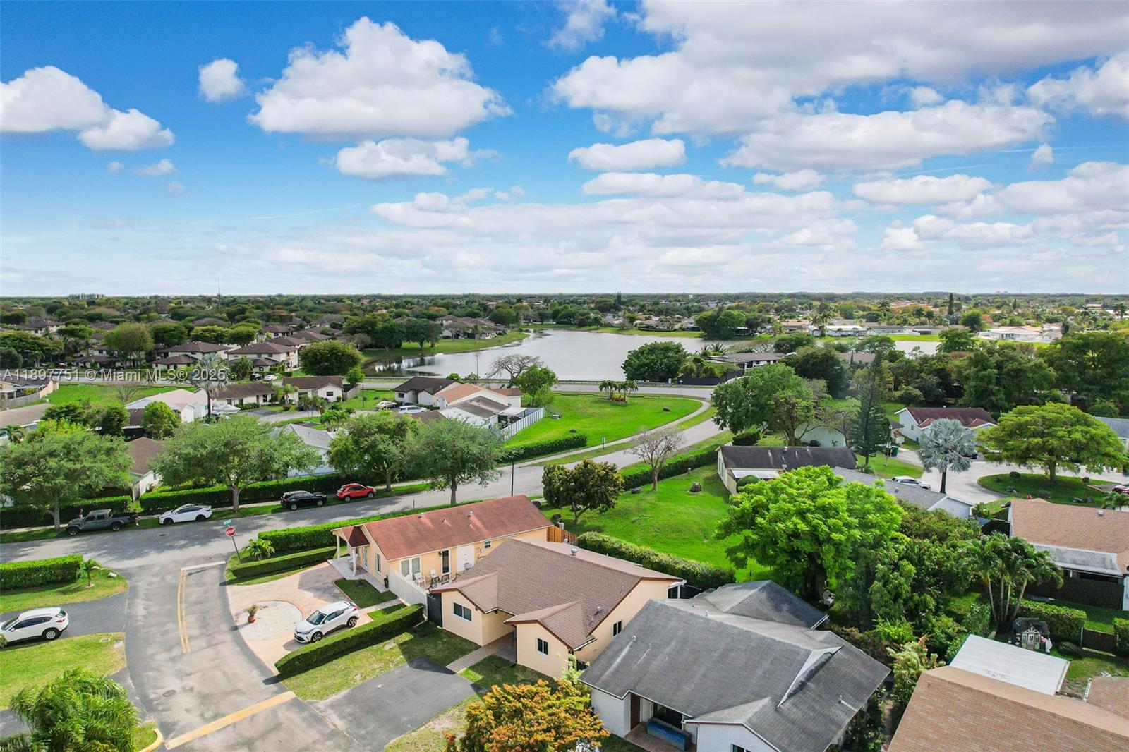 An aerial view shows suburban houses with driveways and lawns near a large lake — 4216 SW 138th Ct, Miami FL 33175, MIAMI, FL