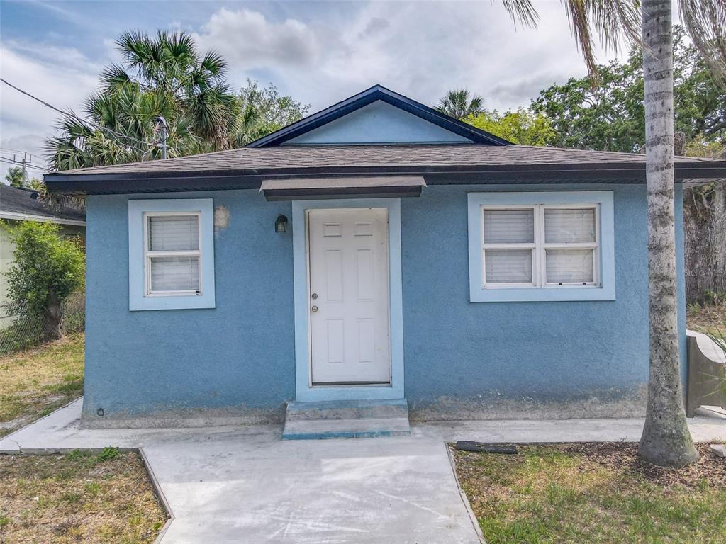 A small, blue, single-story house with a white front door and two windows — 1403 W 13TH PLACE, SANFORD, FL