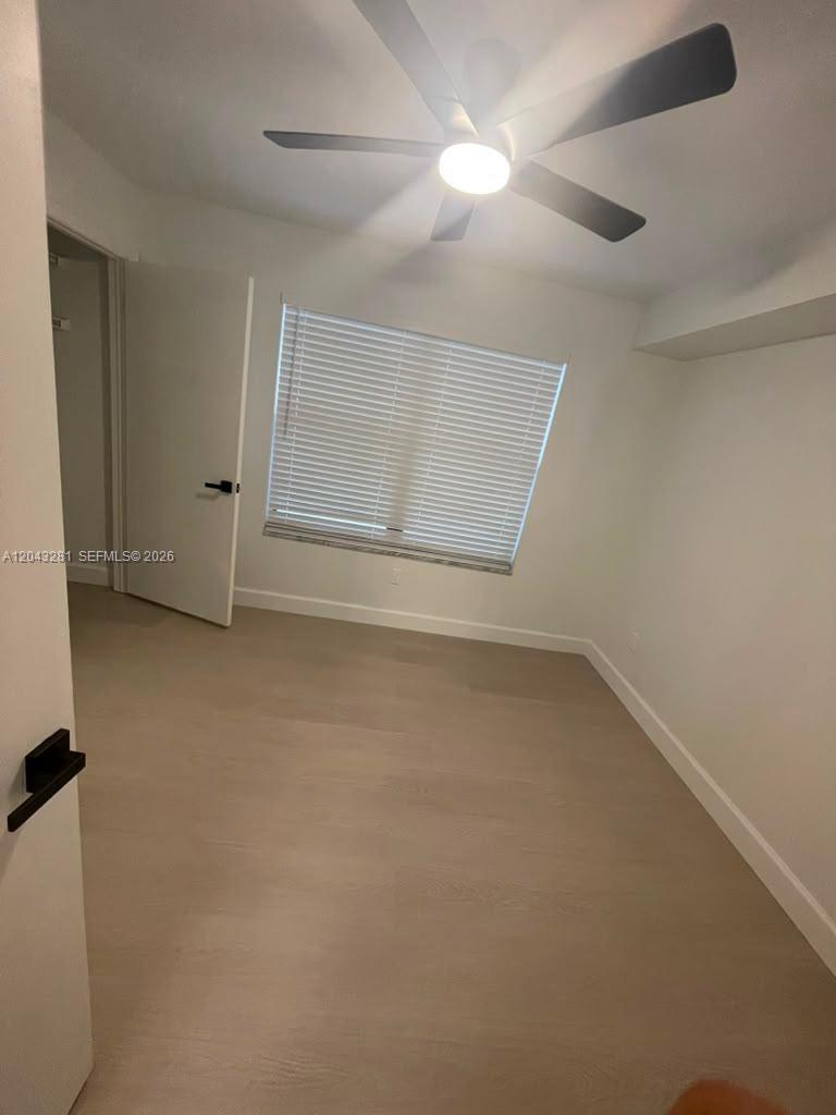 An empty bedroom features light wood-look flooring, white walls, a ceiling fan, and window blinds — 4341 W Mcnab Rd # 21, Pompano Beach FL 33069, POMPANO BEACH, FL