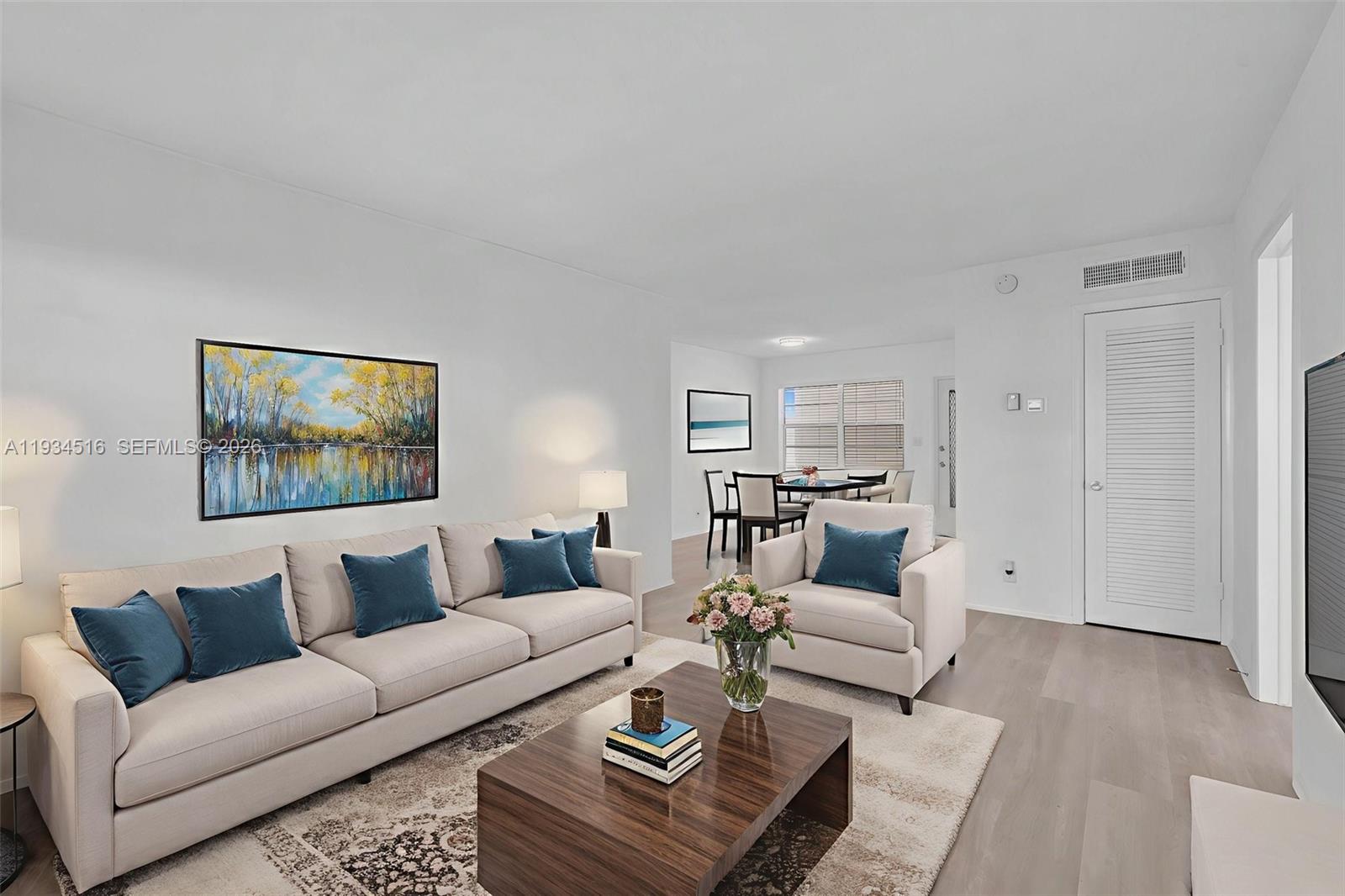 A living room features a beige sofa, armchair, coffee table, and dining area beyond — 1280 NW 43rd Ave # 302, Lauderhill FL 33313, LAUDERHILL, FL