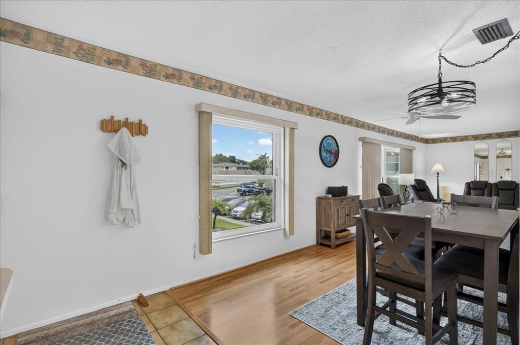 A dining area with wood flooring, a wooden table, and a window overlooking a parking lot — 1250 S PINELLAS AVENUE UNIT 1008, TARPON SPRINGS, FL