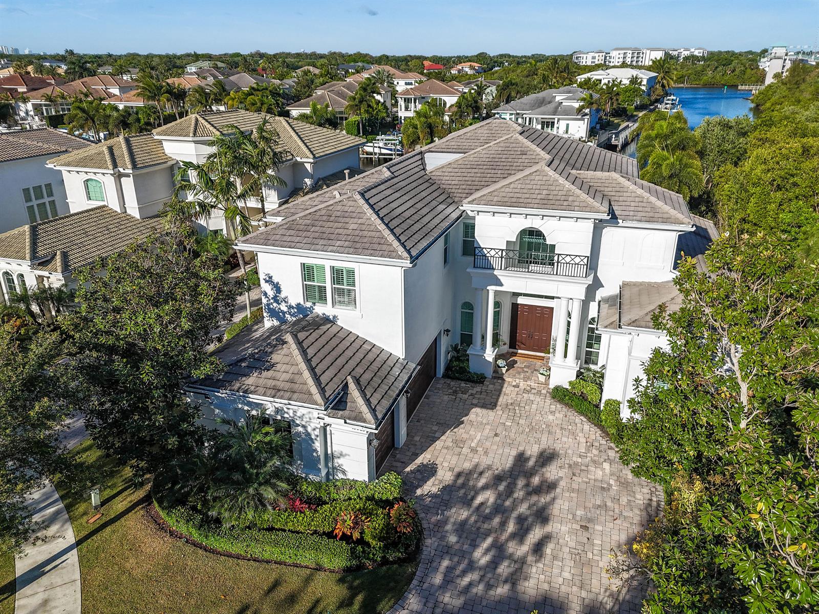 An aerial view of a two-story white house with a tiled roof and paved driveway — 13965 Willow Cay Drive, Juno Beach FL 33408, JUNO BEACH, FL
