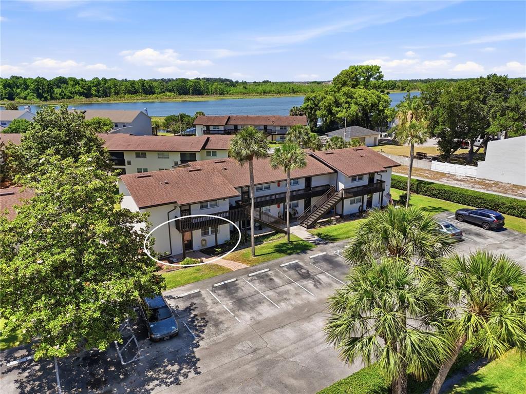 A two-story stucco building features a dark wood balcony, a brick walkway, and landscaping — 900 AVENUE Z SE UNIT A1, WINTER HAVEN, FL