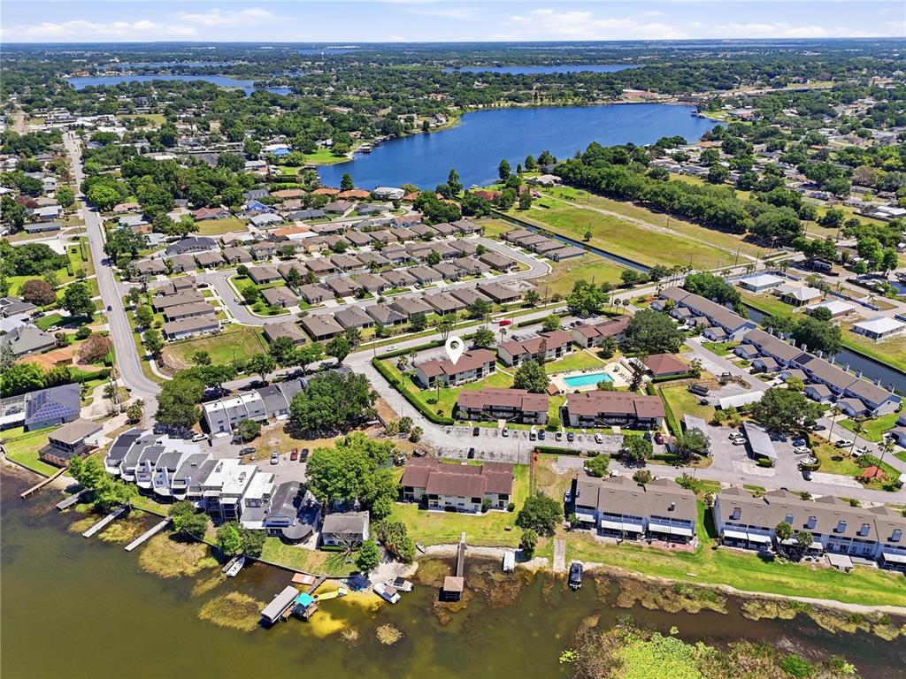 An aerial view shows a residential complex with a swimming pool and parking lots — 900 AVENUE Z SE UNIT A1, WINTER HAVEN, FL