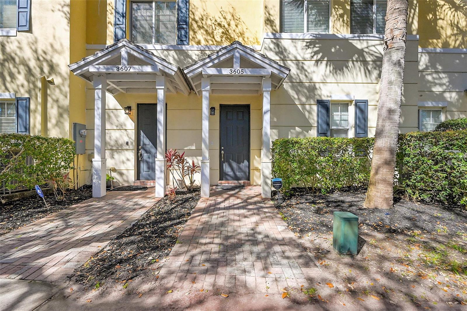The exterior of two adjacent townhome units features brick walkways, covered entryways, and landscaping — 3605 NW 5th Terrace, Boca Raton FL 33431, BOCA RATON, FL