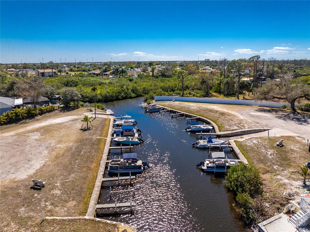 An aerial view shows a canal with multiple boats docked along wooden piers — 258 VIA DE LUNA, ENGLEWOOD, FL