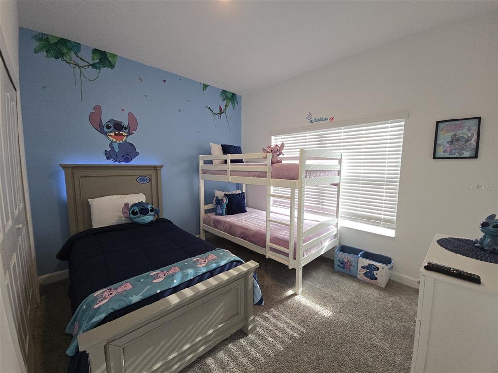 A bedroom features a single bed, a bunk bed, and Stitch-themed wall decor — 1036 LEADER STREET, DAVENPORT, FL