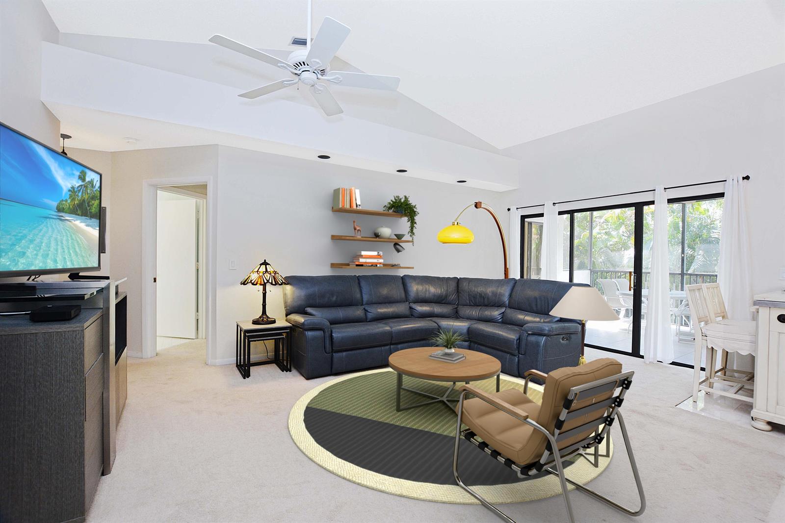A living room features a blue sectional sofa, a round rug, and a ceiling fan — 2406 Aspen Way # 2406, Boynton Beach FL 33436, BOYNTON BEACH, FL
