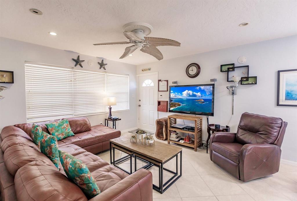 A living room features a brown leather sectional, a matching recliner, and a wooden coffee table — 6020 MIDNIGHT PASS ROAD UNIT 59, SARASOTA, FL