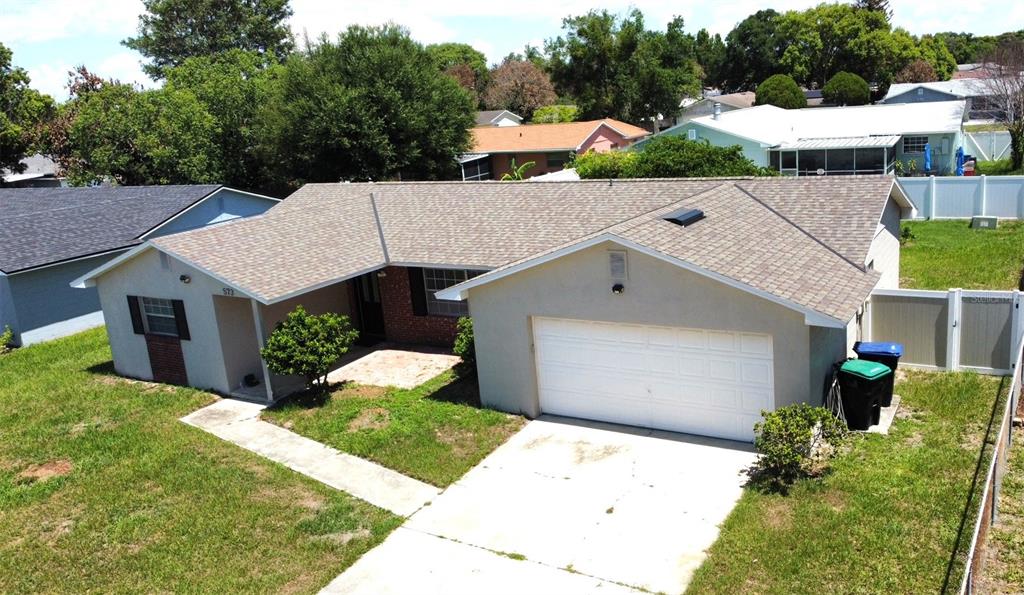 An aerial view of a single-story house with a tan exterior, shingled roof, and garage — 573 BENJAMIN FRANKLIN PLACE, ORLANDO, FL