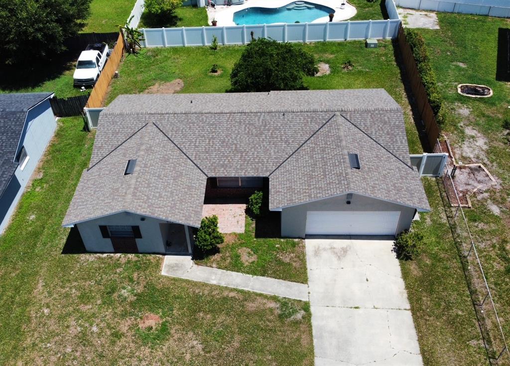 An aerial view shows a single-story house with a shingled roof, garage, and driveway — 573 BENJAMIN FRANKLIN PLACE, ORLANDO, FL