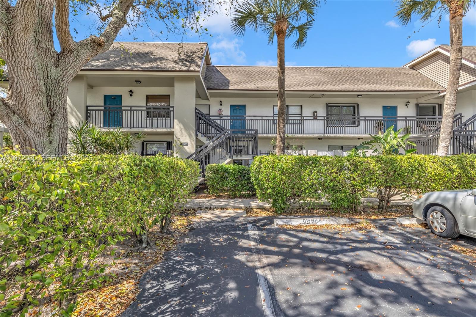 A two-story apartment building features a balcony, exterior stairs, and a parking lot in front — 3014 SW 21st Ter # 352C, Delray Beach FL 33445, DELRAY BEACH, FL