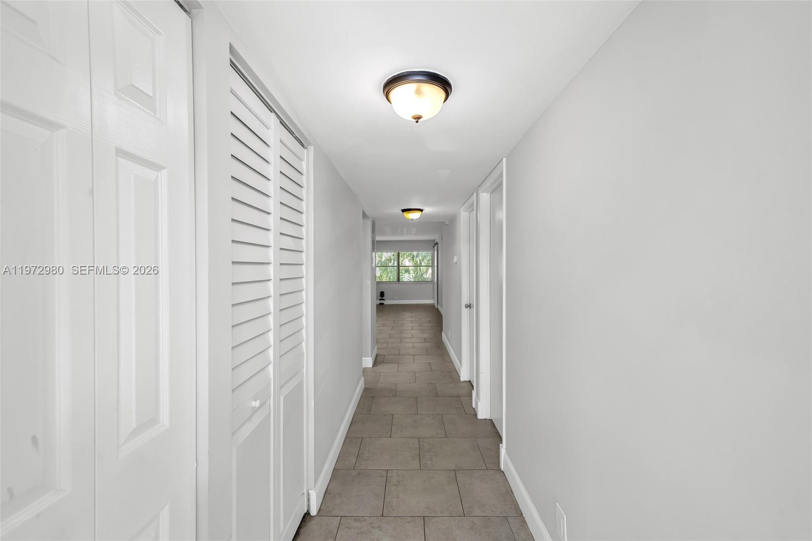 A hallway with light gray walls, tile flooring, and two flush-mount ceiling lights — 3014 SW 21st Ter # 352C, Delray Beach FL 33445, DELRAY BEACH, FL