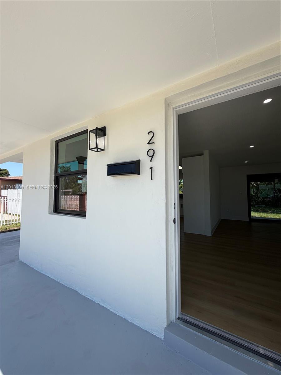 A view of a house entrance with a white exterior wall, black mailbox, and open doorway — 291 NW 184th Ter, Miami Gardens FL 33169, MIAMI GARDENS, FL