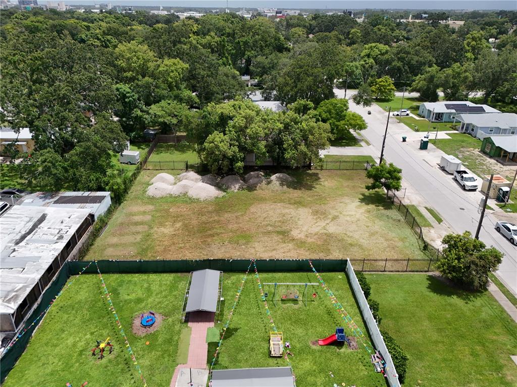 An aerial view shows a vacant rectangular lot adjacent to a fenced playground area — 1221 25TH STREET, ORLANDO, FL